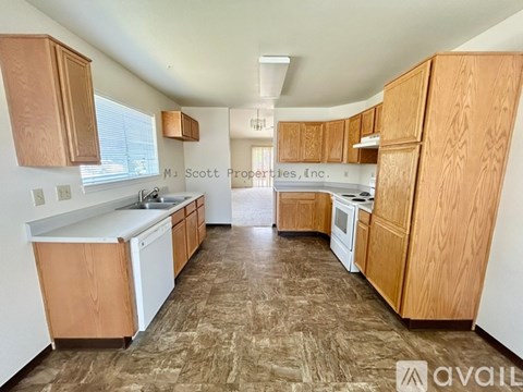 A kitchen with wooden cabinets and a countertop is available for rent.