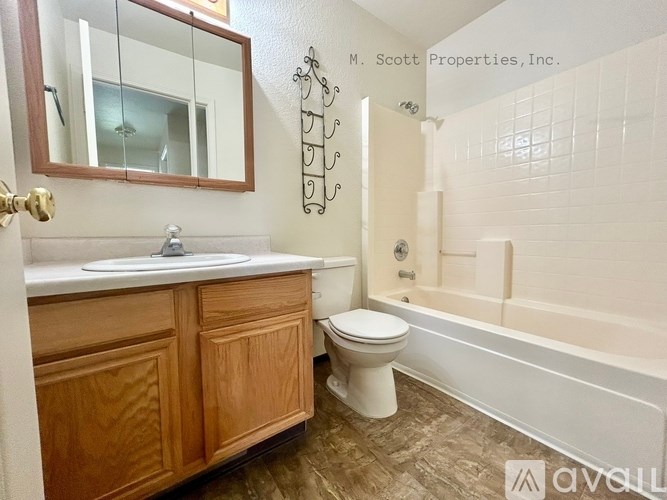 A bathroom with a toilet, sink, and bathtub.