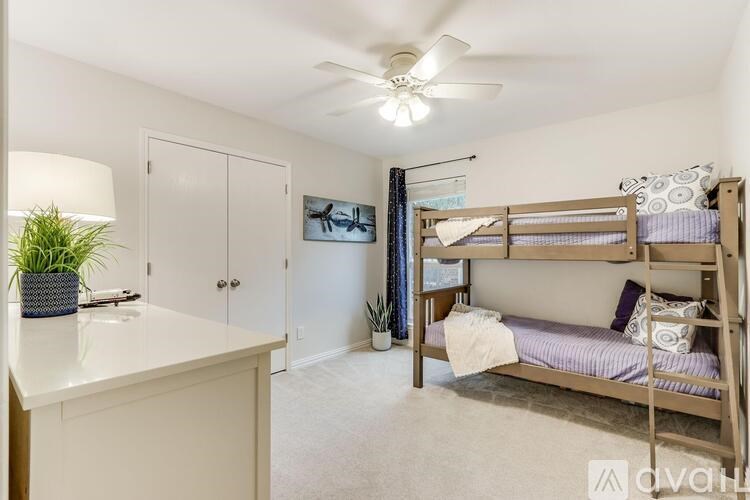 A bedroom with a bunk bed and a desk.