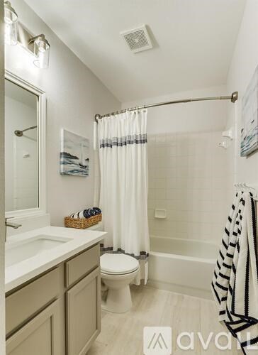 A bathroom with a toilet, sink, and shower.