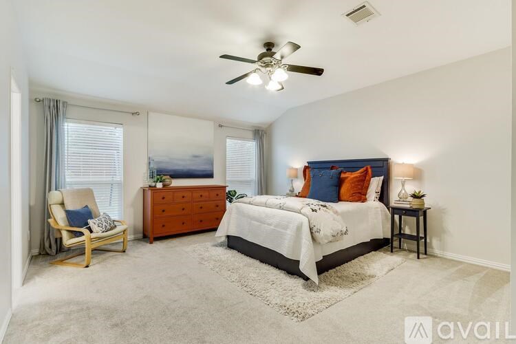 A bedroom with a bed, dresser, and chair.