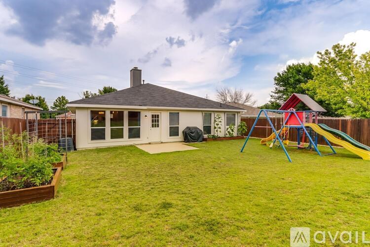 A house with a yard and a slide in the yard.