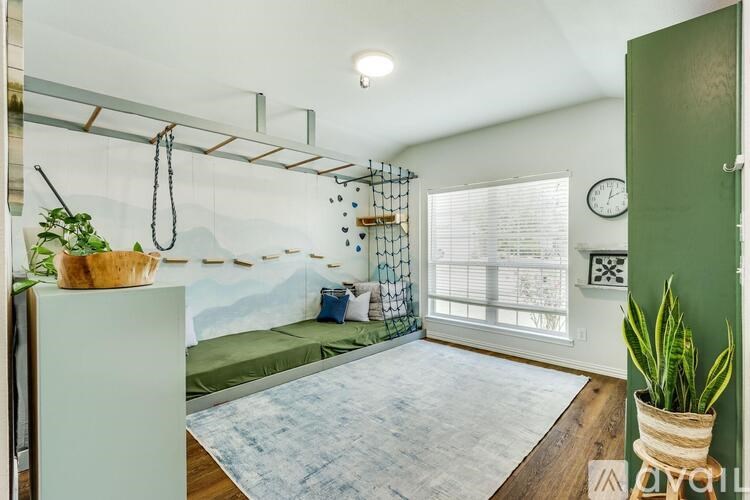 A room with a hanging bed and a hanging plant.