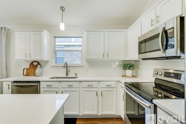 A kitchen with white cabinets and appliances.