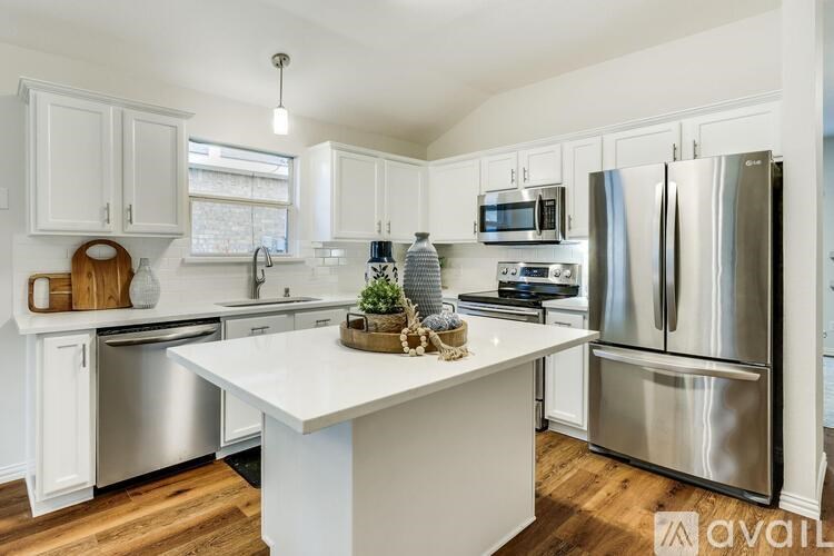 A kitchen with white cabinets and a white island.