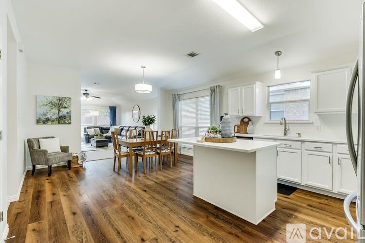 A well-lit kitchen with a dining table and chairs.