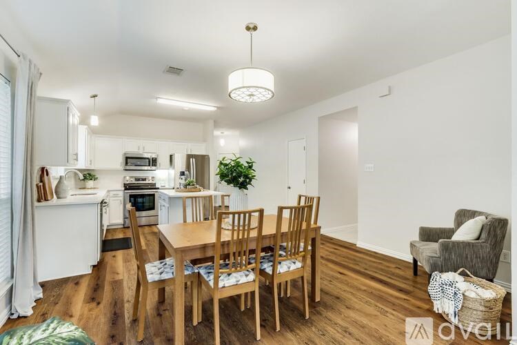 A well-lit kitchen with a dining table and chairs.