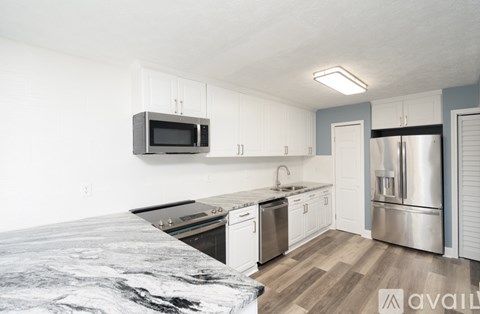A kitchen with a stove top oven, microwave, and refrigerator.