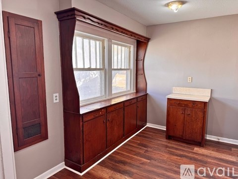 A room with a window and wooden furniture is available for rent.