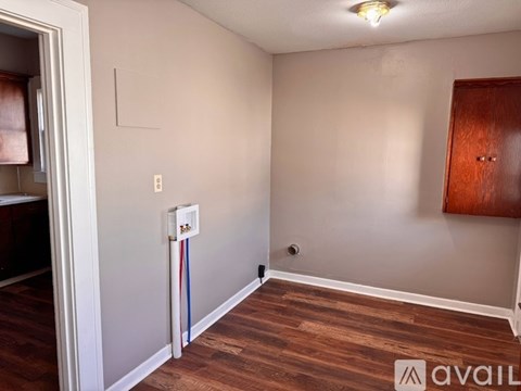 A room with a white wall and a wooden door.