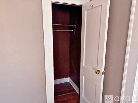 A white door is open to a dark room.