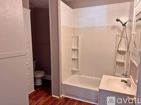 A white bathroom with a toilet, sink, and bathtub.