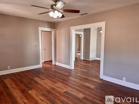 A room with wooden floors and a ceiling fan.