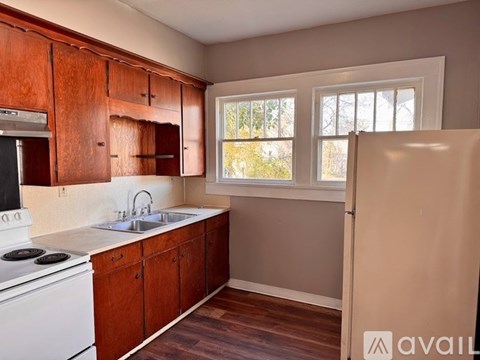 A kitchen with wooden cabinets and a white stove.