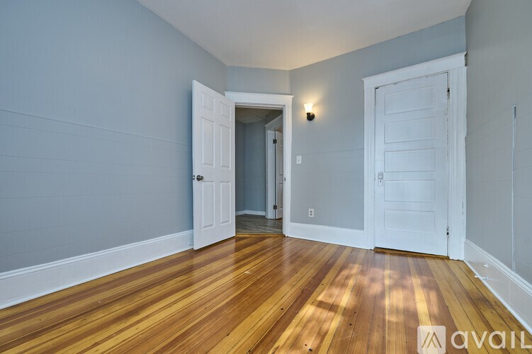 A room with wooden floors and two white doors.