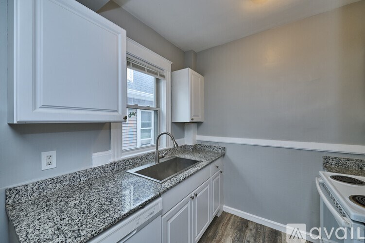 A kitchen with granite countertops and white cabinets.