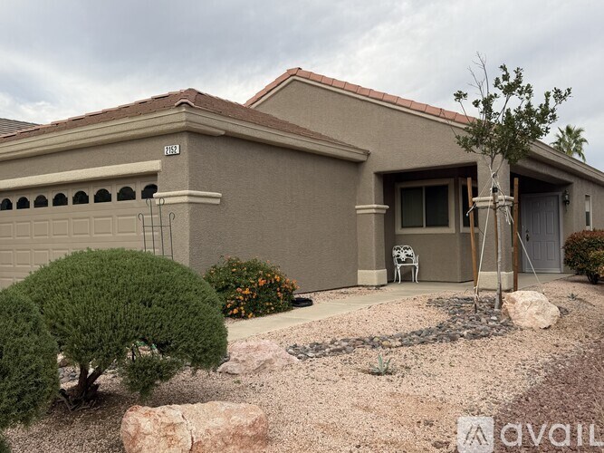 A house with a brown roof and a tree in front.