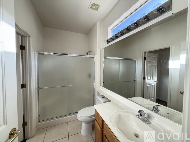 A bathroom with a toilet, sink, and shower.