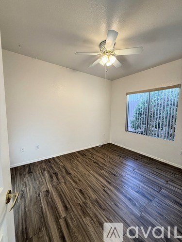 A room with wooden flooring and a ceiling fan.