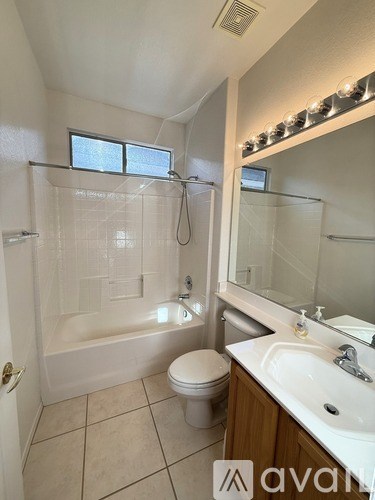 A bathroom with a toilet, sink, and shower.