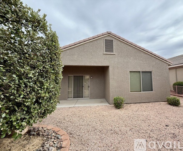 A house with a grey exterior and a gravel driveway.