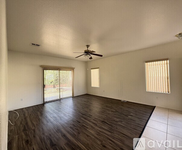 A room with wooden flooring and a ceiling fan.