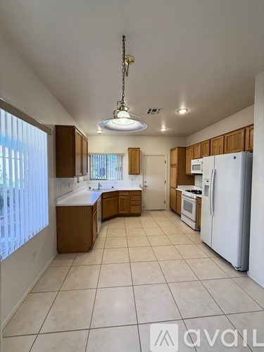 A kitchen with white appliances and wooden cabinets.