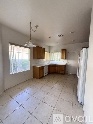 A kitchen with white appliances and wooden cabinets.