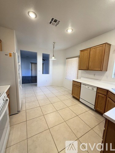 A kitchen with white appliances and wooden cabinets.