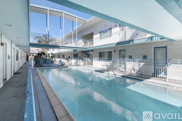 A large indoor swimming pool with a blue tinted water.