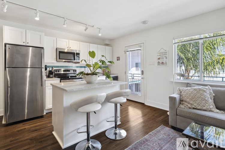 A kitchen with white cabinets and a stainless steel refrigerator.