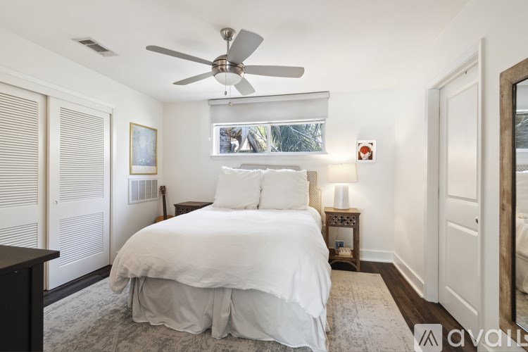 A bedroom with a bed, nightstand, and a ceiling fan.