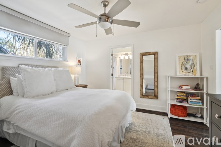 A bedroom with a large bed and a ceiling fan.