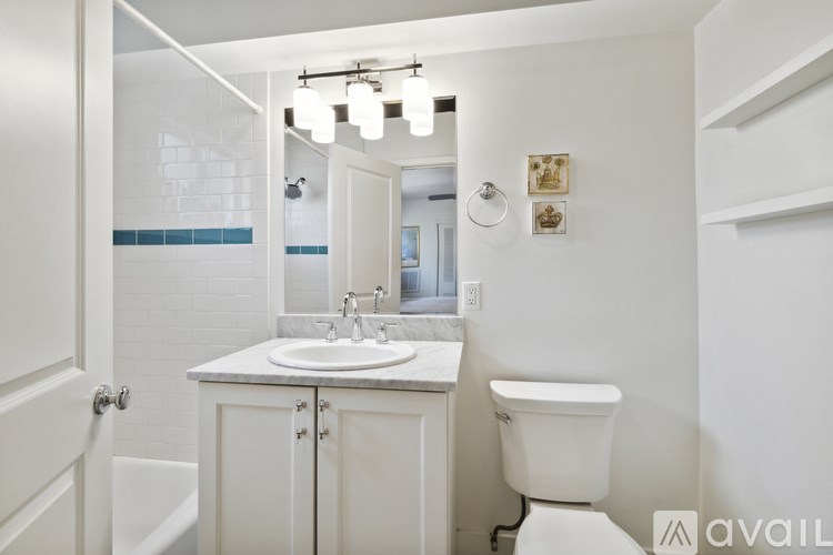 A white bathroom with a sink, toilet and mirror.