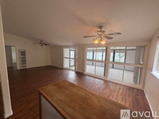 A room with a wooden floor and a ceiling fan.