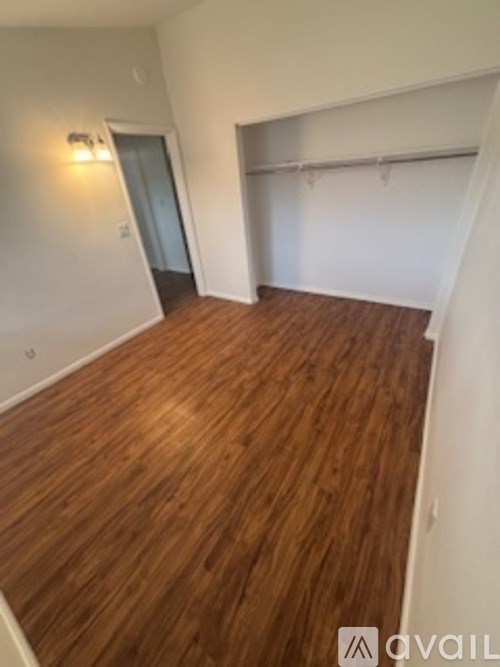 A room with wooden flooring and a white wall.
