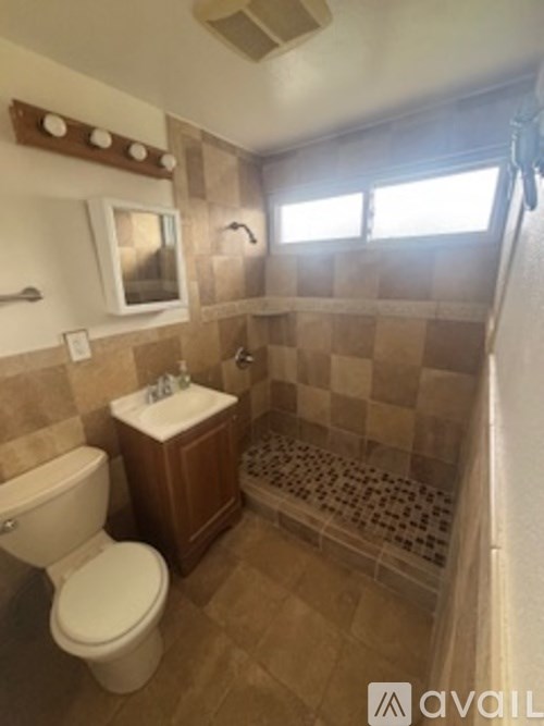A bathroom with a toilet, sink, and shower.