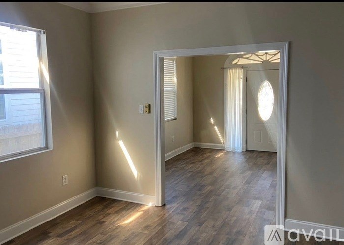 A room with wooden flooring and a white door.