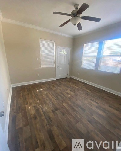 A room with wooden flooring and a ceiling fan.