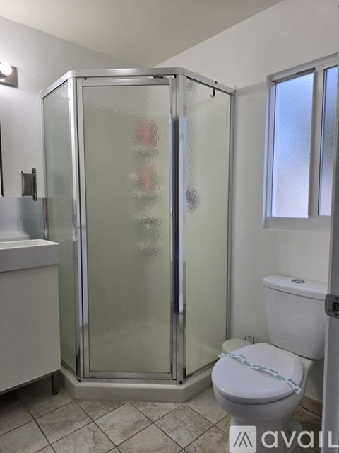 A bathroom with a toilet, sink, and shower.