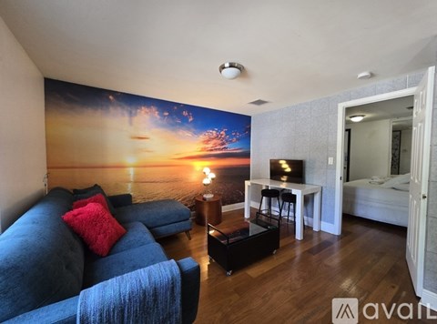 A living room with a large sunset mural on the wall.