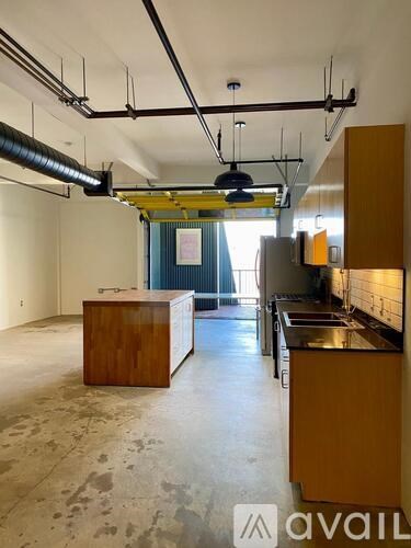 A large empty room with wooden furniture and a blue curtain in the background.