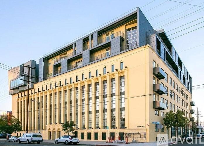 A modern multi-story building with a mix of beige and grey facade and balconies.