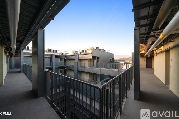 A balcony with metal railings and a view of the city.