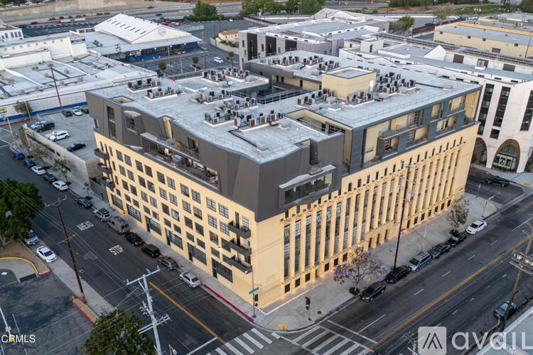 A large building with a lot of windows is in the middle of a city street.