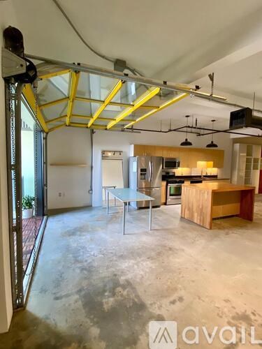 A large open space with a kitchen area and a dining table.