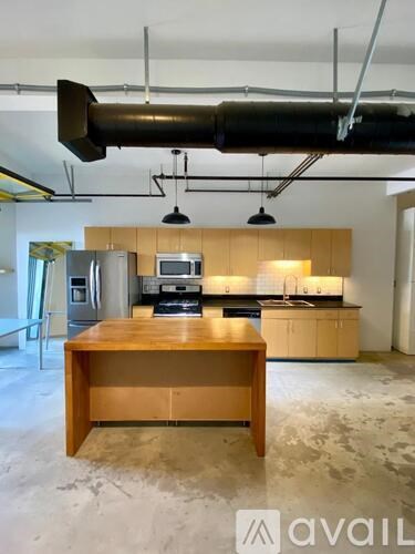 A kitchen with a wooden table in the middle of the room.