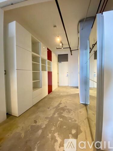 A room with white cupboards and a concrete floor.