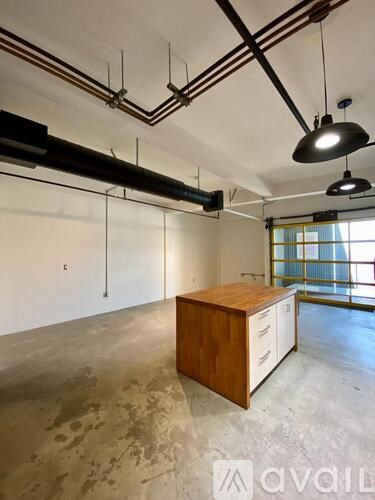A room with a wooden cabinet and a black lamp hanging from the ceiling.