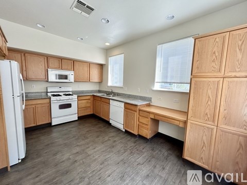 A kitchen with wooden cabinets and a white refrigerator.